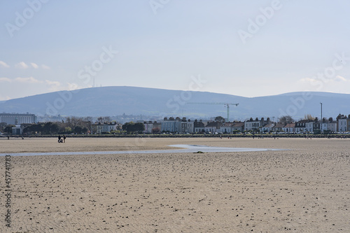 Beautiful bright view on South Dublin and the Mountains seen from Sandymount Beach, Dublin, Ireland during lowest tide. Walking people. Open spaces. High resolution