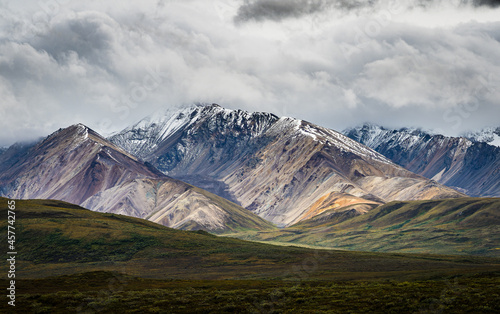 Photo of dramatic, colorful mountains in Denali National Park, Alaska with beautiful clouds