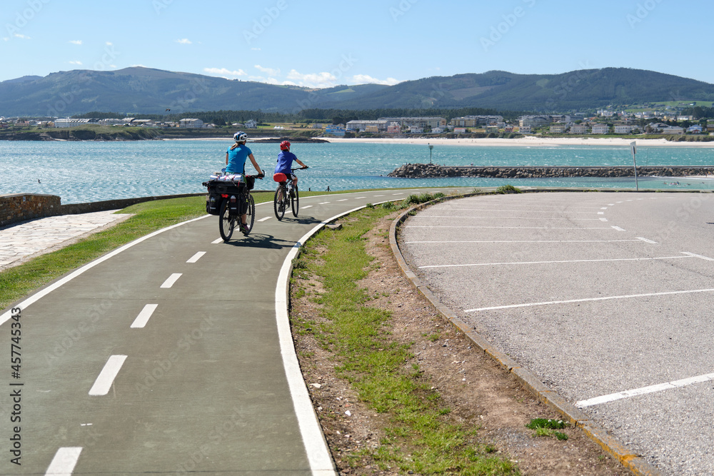 Cyclists riding on a bike path with the sea in the background Cyclists riding on a bike path with the sea in the background
