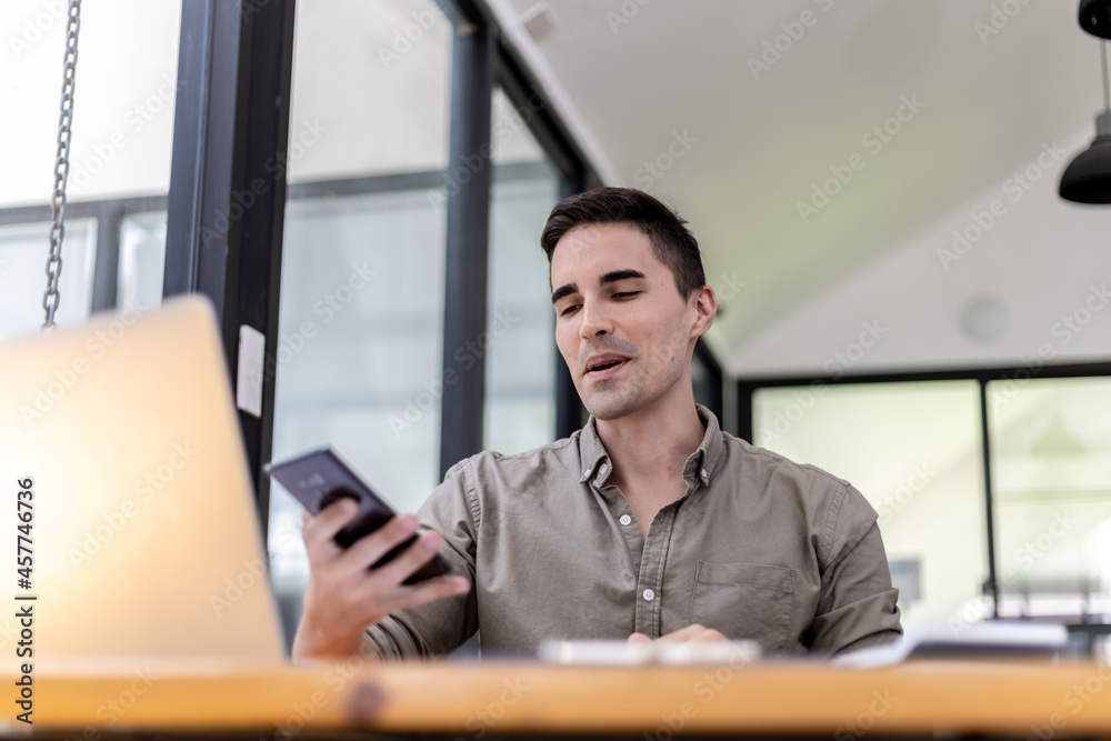 Young businessman is video call with business partner using smartphone, he talks with friends to discuss marketing plans to increase sales for the company. Concept of using technology in communication Young businessman is video call with business partner using smartphone, he talks with friends to discuss marketing plans to increase sales for the company. Concept of using technology in communication