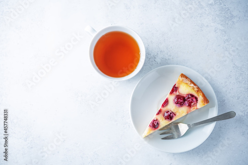 Fresh sweet cheesecake with cherries and almond sprinkles in a plate