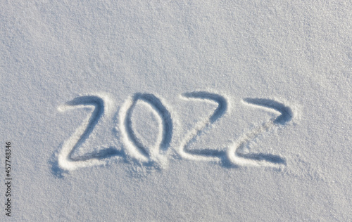 the inscription about the new year 2022 on the snow in winter