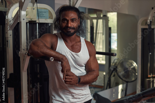 a man athlete Lankian with ruffled hair stands in the gym and looks directly into the camera. High quality photo photo