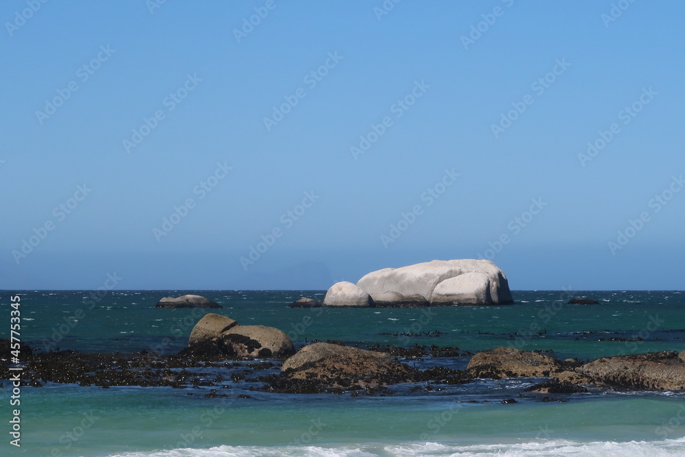 Fototapeta premium Scenic turquoise ocean water with large granite boulders, Cape Town, South africa, Concept of travel, South Africa, Cape town, retirement, holiday, vacation, relaxation. Calming rhythms.