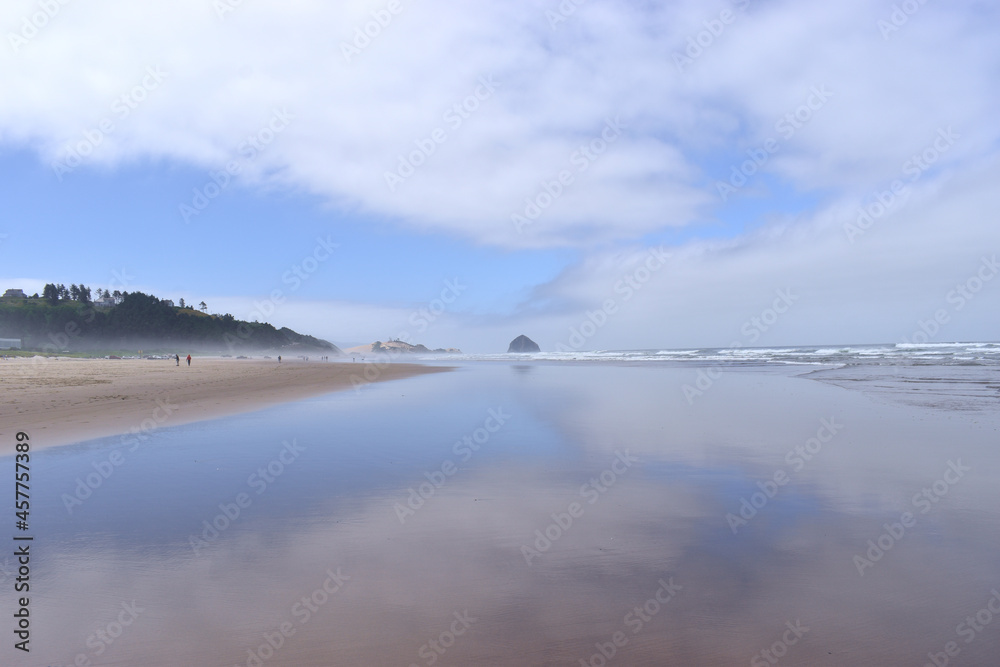 Oregon beach with clouds reflecting off the water