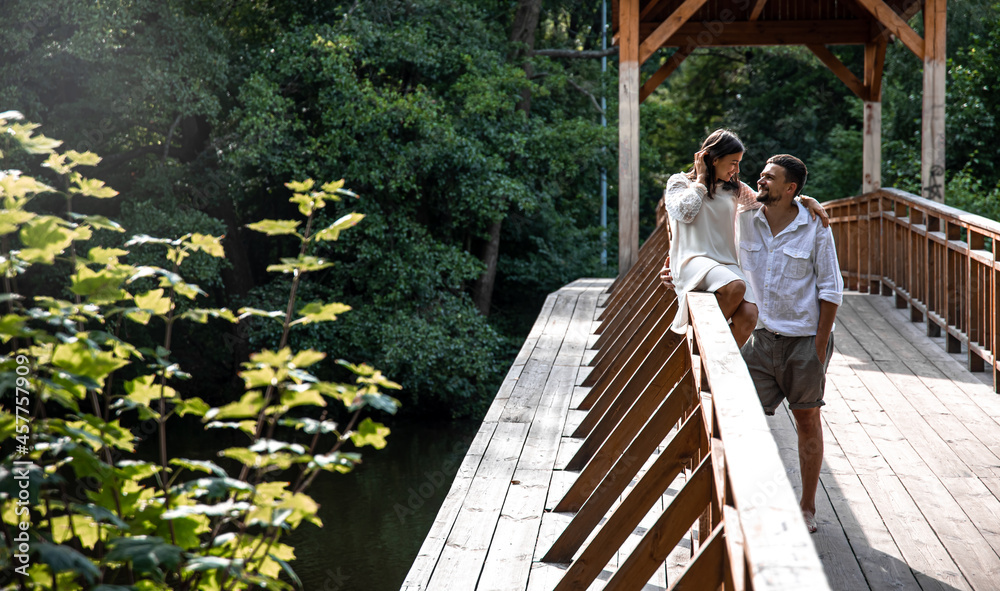 Smartly dressed man and woman on a wooden bridge in the forest. Smartly dressed man and woman on a wooden bridge in the forest.