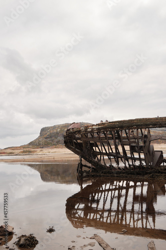 a broken wooden ship near the shore