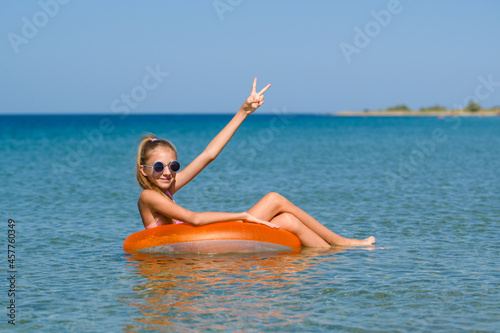 Joyful girl floats on an inflatable ring in the sea. A girl on vacation is resting at a seaside resort.