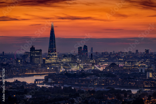 The illuminated skyline of London, United Kingdom, just after sunset with Thames River, Tower Bridge and modern office skyscrapers in the City