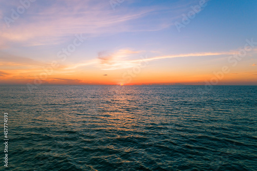 Fototapeta Naklejka Na Ścianę i Meble -  Aerial view Beautiful view sunset over sea surface beautiful wave Amazing light sunset or sunrise sky over sea beach with wave crashing on sandy shore