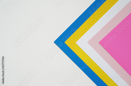 abstract background concept with stacking of color paper in geometric pattern, layers of blank pink paper and white, yellow, blue color on white background.