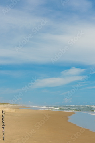 sand beach and blue sky. vertical orientation. copy space.