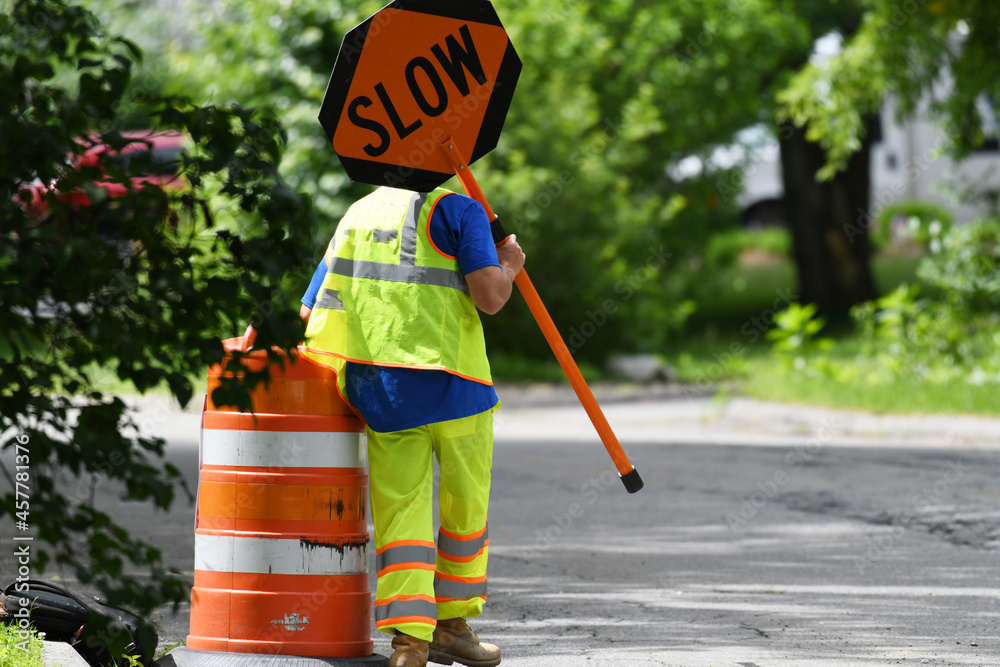 outdoor worker hold slow sign at road construction site - obrazy, fototapety, plakaty 