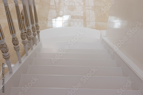 carved wooden staircase with white paint and gold finish