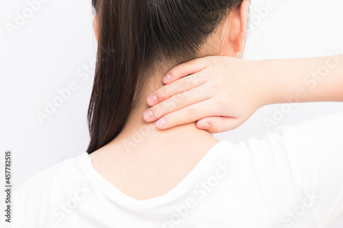stressed girl feels that her neck is pain and massages it to relax her neck a bit more.