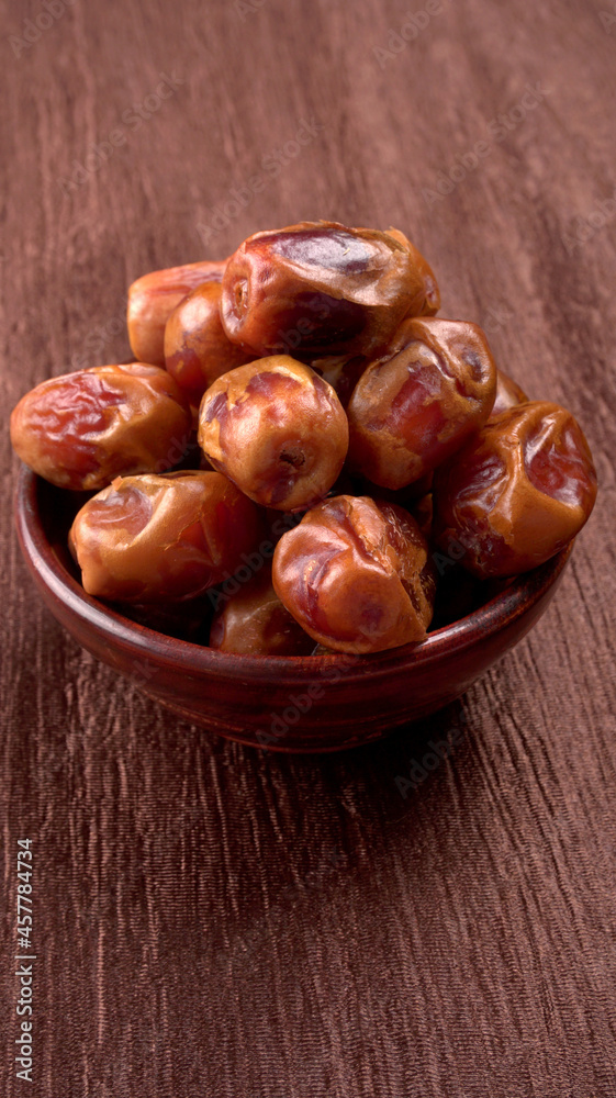 Dates in wooden bowl on background. dried dates fruit. Dates in wooden bowl on background. dried dates fruit.