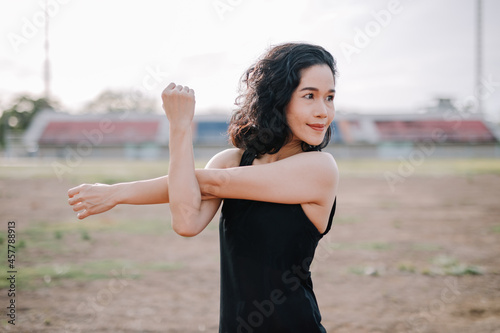 A beautiful woman stretching her body before running in the morning with a bright smile on her face. women's health care concept