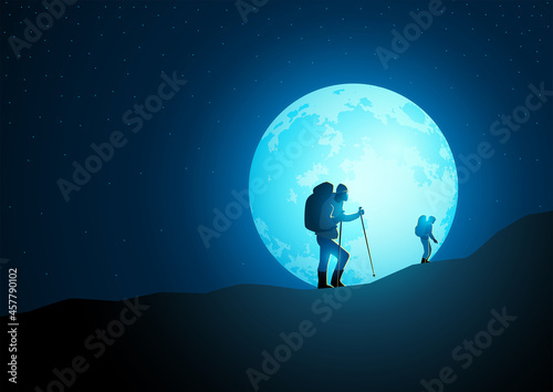 Trekkers with backpack trekking on mountain with beautiful full moon on the background