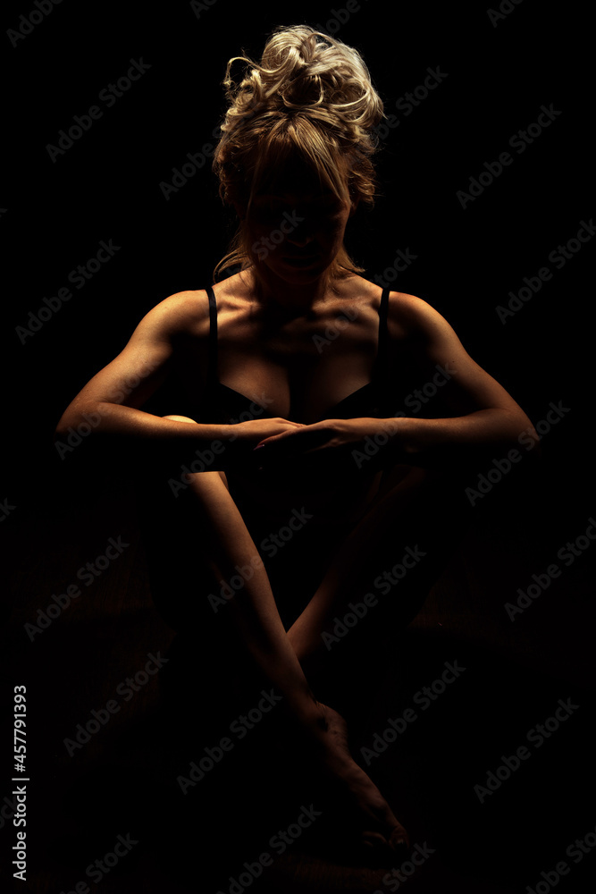 Nude Woman silhouette in the dark. Beautiful Naked Body Girl sitting crossing legs. Sexy Naked sensual beautiful girl. Nude Woman silhouette in the dark. Beautiful Naked Body Girl sitting crossing legs. Sexy Naked sensual beautiful girl.