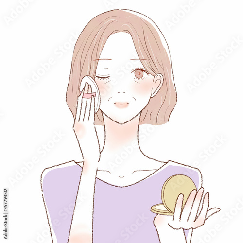 パウダリーファンデーションをパフで顔に塗る中年女性