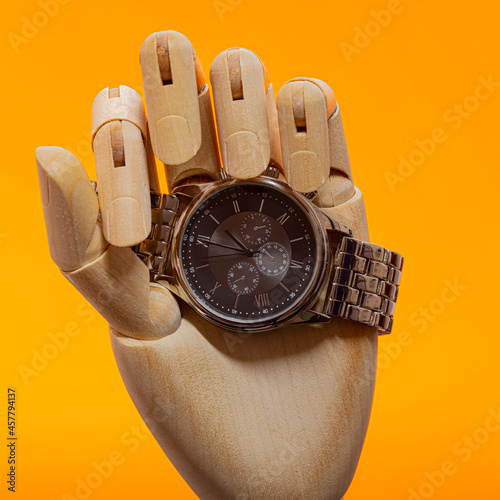 Картината върху платно Wooden Hand with moden chronograph watch on an orange background