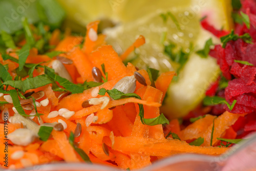 Fresh healthy vegan salad with carrots, various seeds and fresh parsley. High resolution close up macro photo