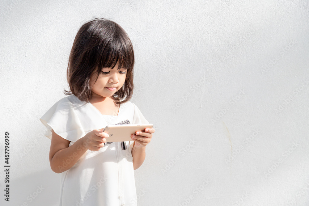 Photo of a little girl using a mobile phone isolated over white background Photo of a little girl using a mobile phone isolated over white background