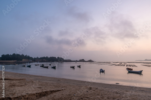 At the seaweed farm before sunrise in the morning, there are seaweed rows and boats