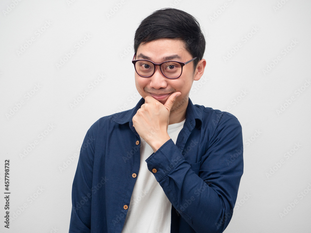 Asian man wearing glasses touch his face and smile looking at camera Asian man wearing glasses touch his face and smile looking at camera