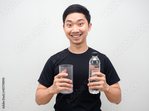 Cheefull man asian holding water bottle and glass in hand white background photo