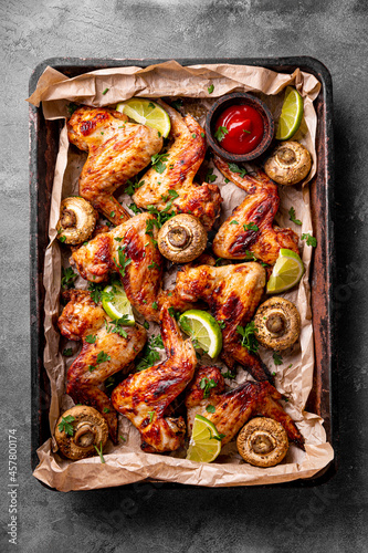 Baked homemade chicken wings with mushrooms and lime, vertical photo