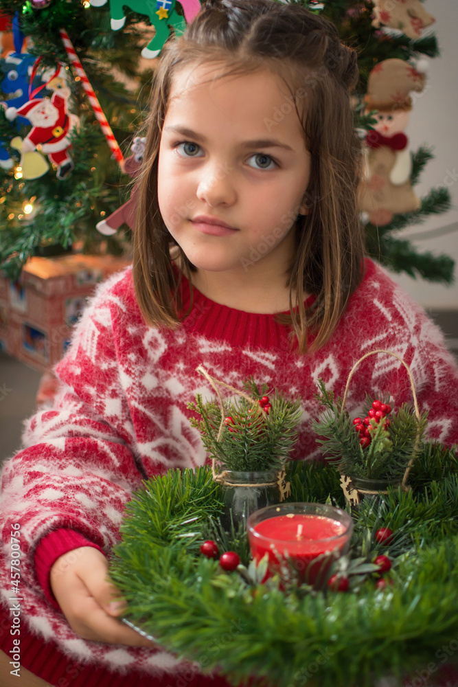 6 Year Old Girl Playing With Christmas Decorations At Home. Little Girl Dressed In Christmas Clothes.