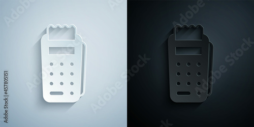 Paper cut POS terminal with inserted credit card and printed reciept icon isolated on grey and black background. NFC payment concept. Paper art style. Vector