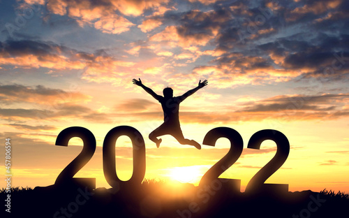 Silhouette young man jumping on the mountain and 2022 years while celebrating new year, happy victory and success concept.