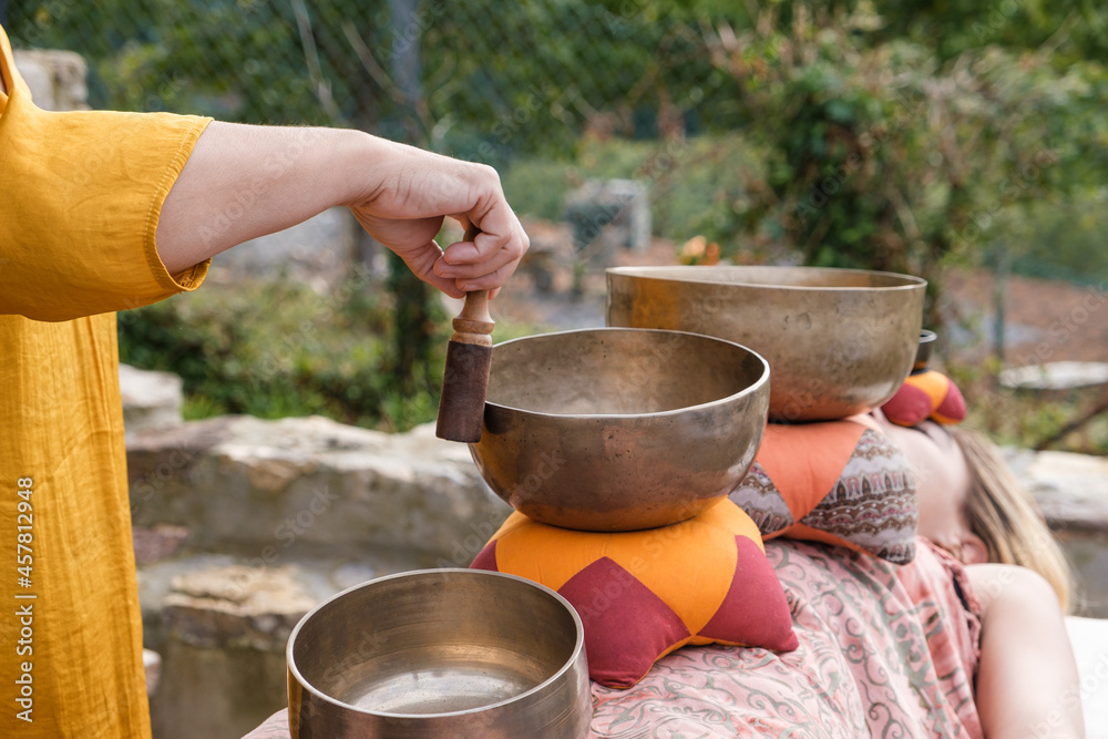 Alternative therapy with Tibetan singing bowls in an outdoor spa. Alternative therapy with Tibetan singing bowls in an outdoor spa.