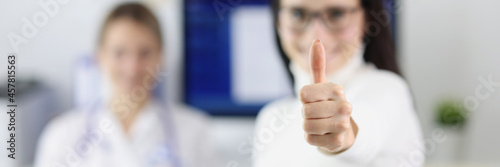 Female patient showing thumb up at doctor appointment closeup