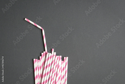 Glass with straw made up of paper straws on black background. Party or no plastic concept.
 photo