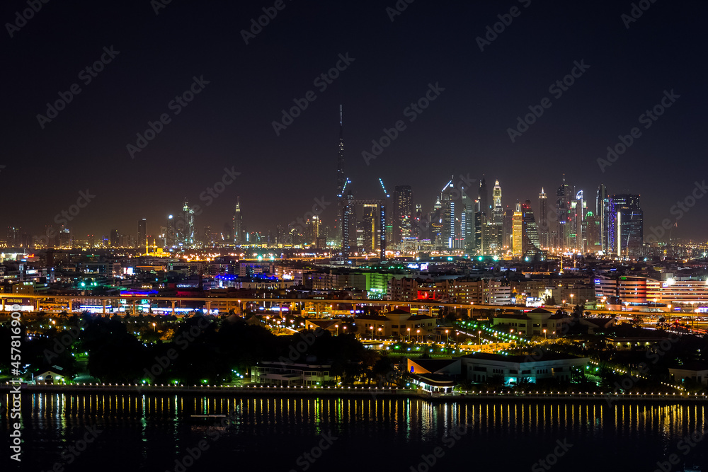 
Dubai, UAE – January 16, 2016 – City skyline seen from Deira district in a beautiful, peaceful night. In the foreground, the ships in Port Saeed docks