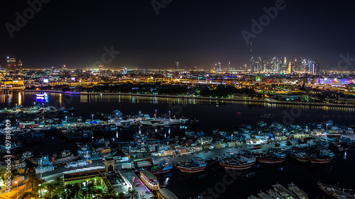  Dubai, UAE – January 16, 2016 – City skyline seen from Deira district in a beautiful, peaceful night. In the foreground, the ships in Port Saeed docks