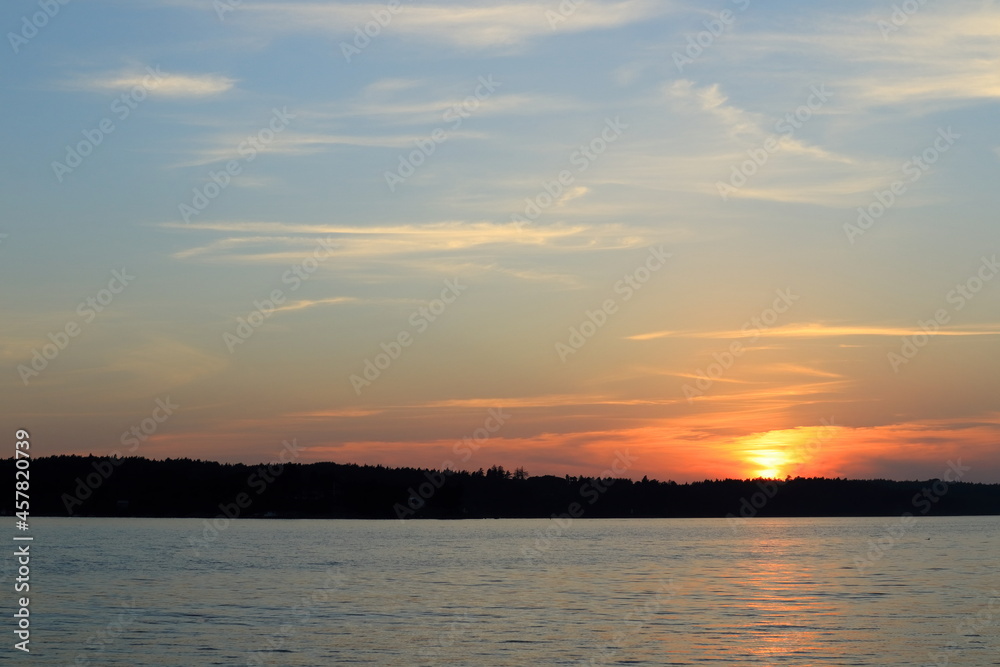 Beautiful sunset at a Scandinavian lake called Malaren or Mälaren. Outside in the evening. Concept of freedom and peace. Copy space for extra text. Stockholm, Sweden, Europe.