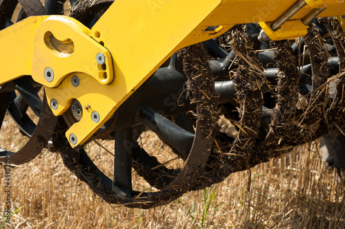 fragment of a heavy disc harrow on a field background