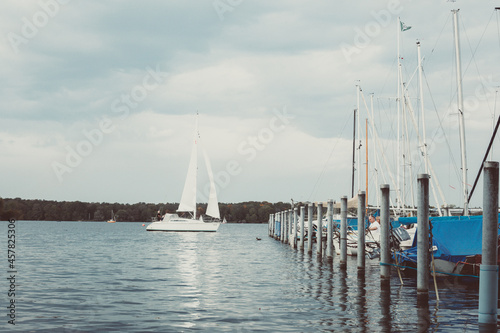 Barche a vela, regata nel lago berlinese Tegel See. Colori freddi invernali contrastati dal blu delle coperture delle barche.
