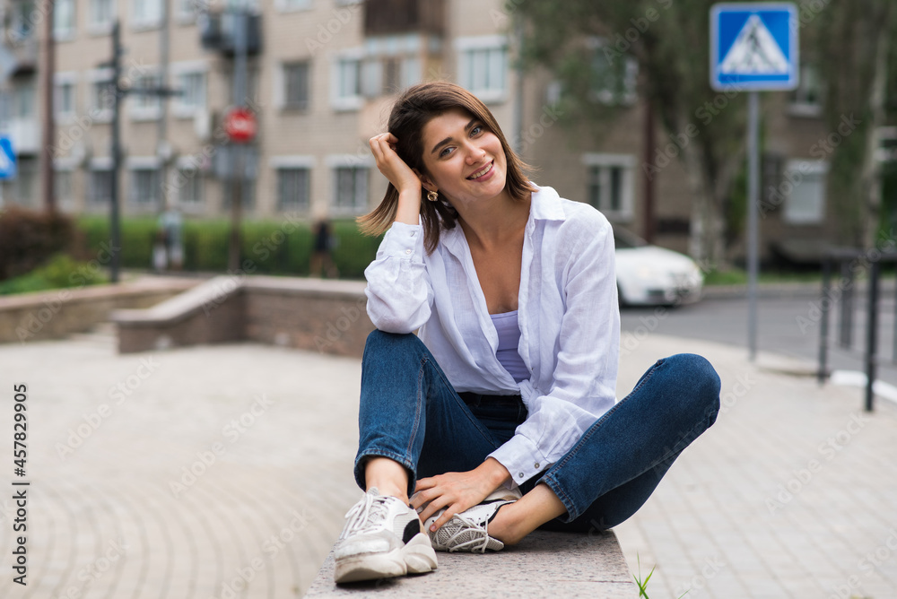 Attractive, happy and stylish brunette Caucasian girl posing on the street. Lifestyle and fashion concept. Attractive, happy and stylish brunette Caucasian girl posing on the street. Lifestyle and fashion concept.