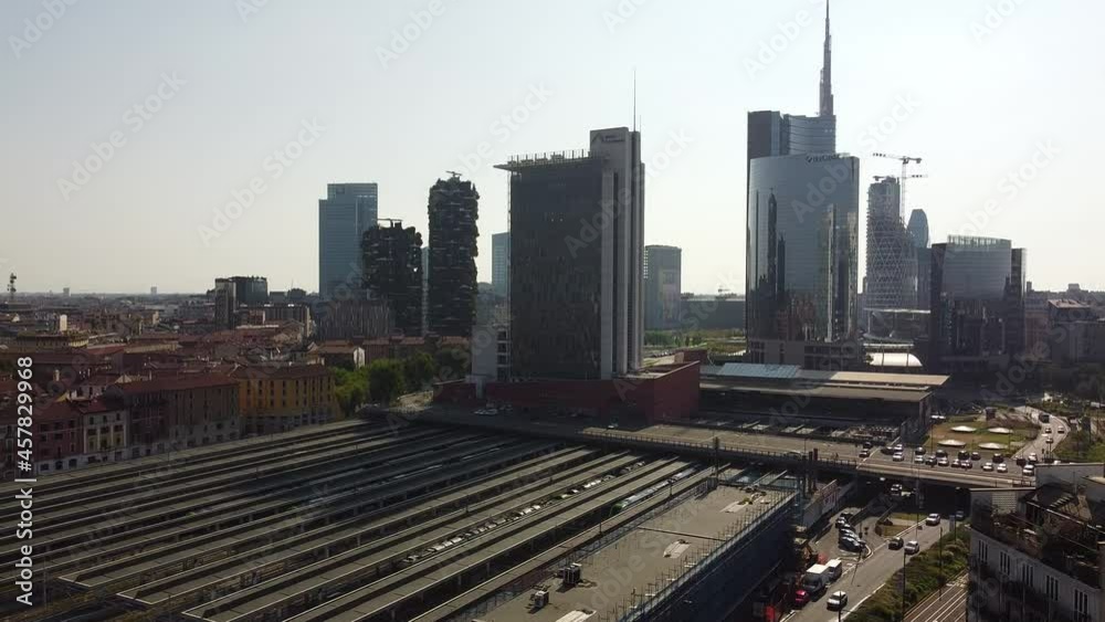 Panorama of downtown Milan Italy skyline and train station as trains arrive on a business day 