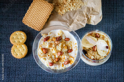 Delicious and healthy yogurt dessert with banana, biscuits and nuts.