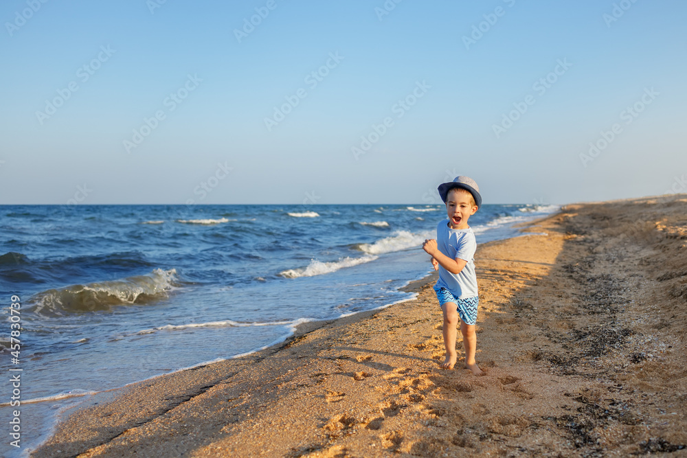 little boy with colorful kite on the beach