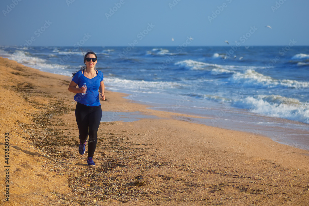 woman running by the sea beach and listening music