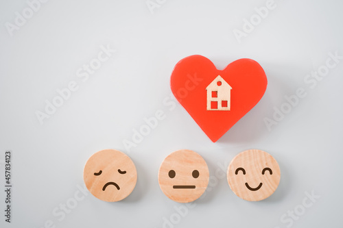 wooden miniature house on red heart shape with emotion icon on circle wood , wellness, wellbeing, home sweet home, happy family , healthy concept