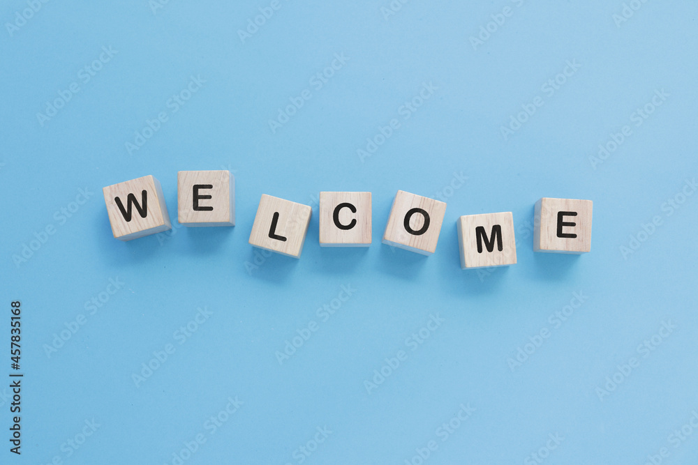 Obraz premium Word welcome on wooden cubes on blue background