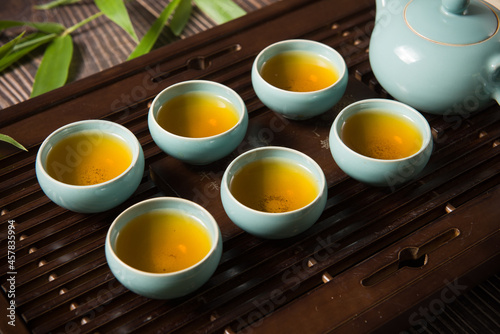 cups of green tea and teapot on tea tray 